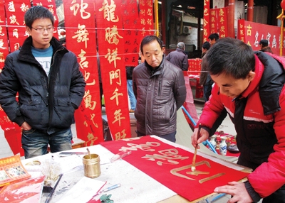 2月5日,书法爱好者在兰州城隍庙为市民挥写新春对联,祝福百姓大吉大利