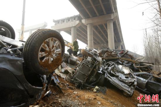 2月2日，大桥爆炸坍塌现场，坠桥的汽车堆积在一起像是一处废旧汽车回收站。中新社发 王中举 摄