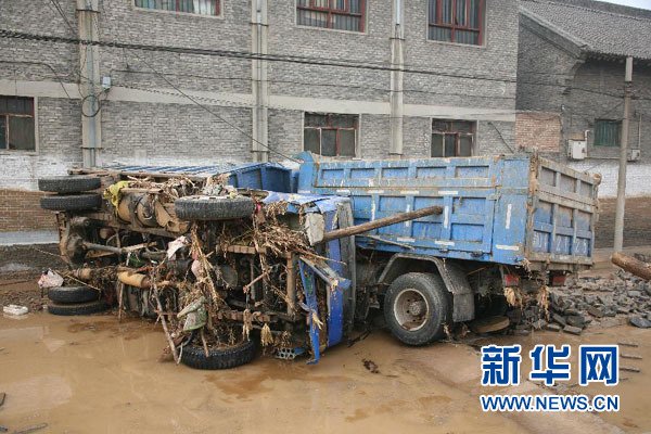 在山西省洪洞县甘亭镇南羊獬村，一辆货车被大水冲翻在地（2月17日摄）。