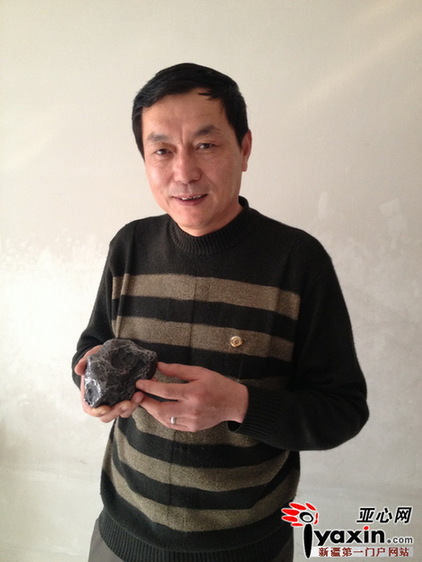 图为新疆陨石收藏家协会会长童先平展示他收藏