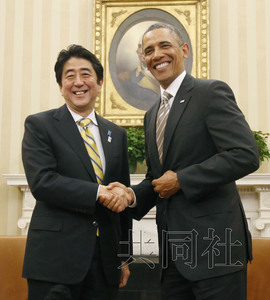 2月22日，日本首相安倍晋三和美国奥巴马在白宫的总统办公室接受记者采访。图为采访结束时，两人握手合影。（共同社）
