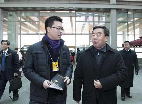 3月1日，来自江西省的全国政协委员抵达北京，出席全国政协十二届一次会议。这是全国政协委员傅克诚（前右）在北京首都国际机场接受采访。新华社记者 王晔 摄