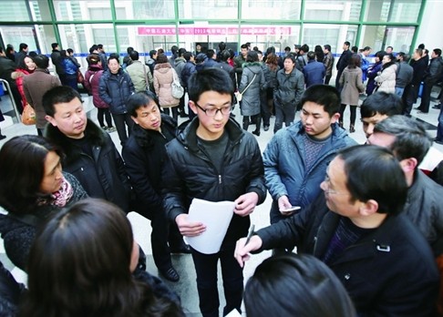 昨日，一名考生刚走出面试考场就被一群家长和考生围住，询问考试内容　通讯员　刘积舜摄