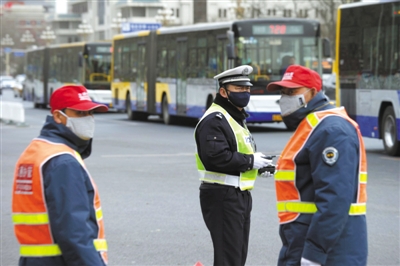 昨日，长安街，交警和协管员戴口罩执勤。遭遇扬尘天气，北京各主要街道上交警及治安民警佩戴黑色口罩，口罩为统一设计。