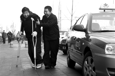 3月7日，北京汇友出租车公司司机康建平正将病人搀下车送往医院。 新京报记者 尹亚飞 摄