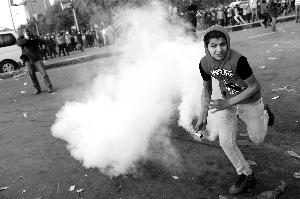 3月9日，在埃及首都开罗，一名抗议示威者手持催泪弹。新华/法新