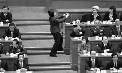 会议休息时间，人大代表傅莹的“同桌”为其拍照。昨天，十二届全国人大一次会议在北京人民大会堂举行第五次全体会议。