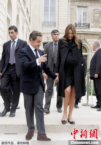 资料图：2011年9月17日，巴黎爱丽舍宫，萨科齐与妻子布吕尼手拉手走下台阶。