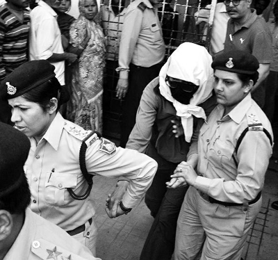 3月16日，在印度中央邦瓜廖尔，遭到轮奸的瑞士籍女子（蒙面者）在警察的护送下进入医院检查