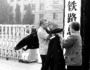 来自哈尔滨铁路局的退休老火车司机杨浩文老先生在老伴的帮助下换上火车司机特有的工作服跟“老东家新牌子”合影留念。晨报记者 史春阳/摄