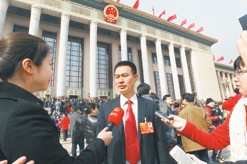 龙秋华代表在人民大会堂前接受记者采访.本报记者 张目 摄