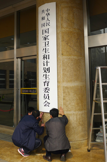 3月17日上午,工作人员在原卫生部大楼门口更换新牌.新华社 图