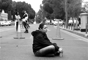 一名塞浦路斯大众银行的员工坐在议会大楼外参加抗议活动 新华社发