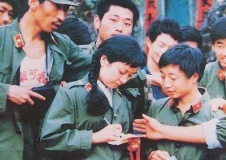 在老山前线参加慰问演出的彭丽媛为战士们签名