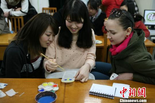图为南开大学留学生在绘制风筝。任永华摄