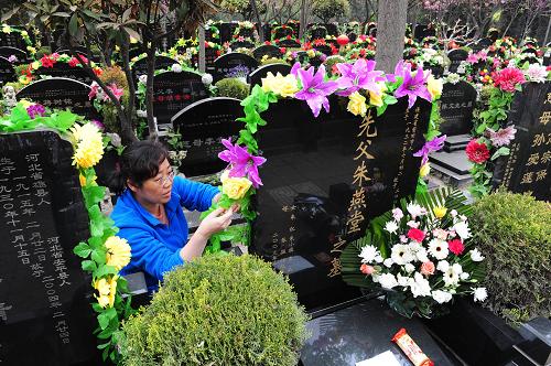 4月2日,在西安市三兆公墓,一位市民敬献鲜花和绢花,祭奠亲人.