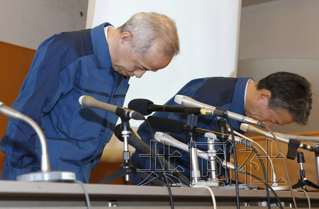 4月10日下午，东京电力公司社长广濑直己（左）在福岛县�A叶町召开记者会，就地下蓄水池辐射污水泄露问题道歉。