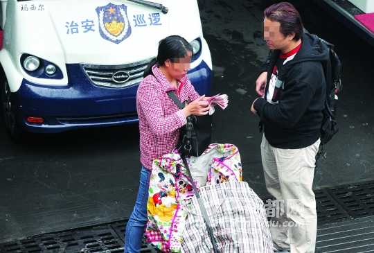   昨日下午，罗湖口岸深圳出口，有从香港过关的男子将包里的奶粉转手赚钱。南都记者 徐文阁 摄