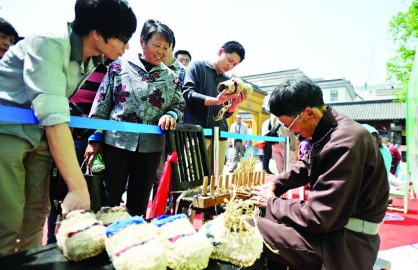 昨天的活动现场,张家港非遗传承人现场展示"芦花鞋制作"吸引了许多