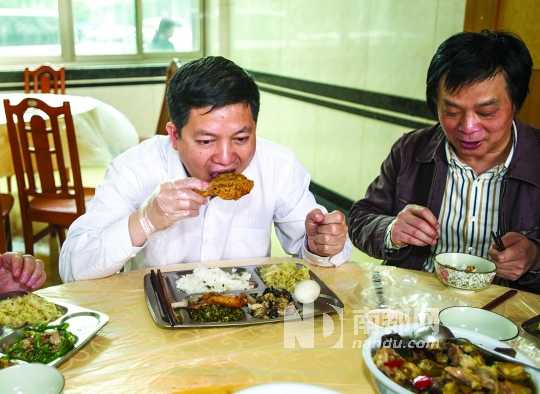 4月17日中午，长沙，湖南省畜牧水产局局长袁延文(左)坦然吃鸡肉，他希望以此打消许多人因禽流感而产生的对吃鸡肉的恐惧。CFP供图