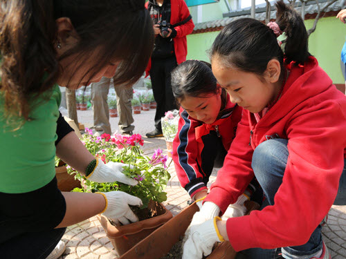 学生们向志愿者学习如何栽植各种绿植