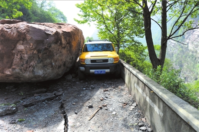 许多巨石坠落阻断交通，图为318国道飞仙关路段被大石阻断。新华社发