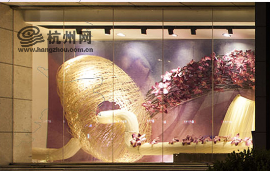 杭州网讯 今年5月1日,在延安路上城段(庆春路吴山广场),一条装扮的充满紫色浪漫的大街就将全新亮相,一百余个沿街商家橱窗打造的延安路金橱窗艺术展也会在当天启幕,就如同主办方说的,这是一份献给城市的礼物。 一谈到礼物,谁都会像小孩子一样充满好奇与期待,悄悄的拨开包装纸的一角,看看这个礼物到底是什么。今天记者来到了上城区,和网友一起拨开这神秘的包装纸,先来看看这份城市礼物到底有多精彩。 百余橱窗全手工装扮 纸板箱、泡沫塑料、铁丝、绒布这些平日里见怪不怪的小东西,经巧手加工,竟变成了一朵朵