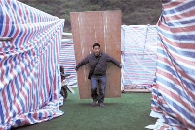 22日，宝兴县中学，居民搭帐篷。新京报记者 吴江 摄