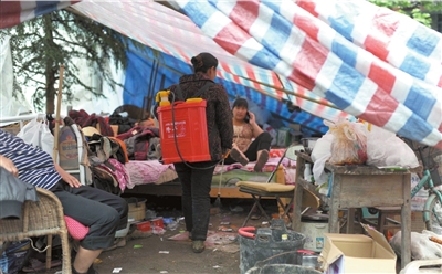24日，芦山县清仁乡，工作人员在灾民帐篷里喷洒消毒水。京华时报记者王苡萱摄