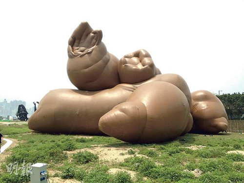 由美国艺术家Paul Mccarthy设计、名为《复杂物堆》的充气雕塑“粪便”，意念是盼颠覆市民对艺术“美感”的特定框架，令市民观赏时产生疑惑，之后微笑。（明报图）