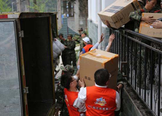 苏宁社工志愿者与救援部队将物资安置在双石镇物资接收点