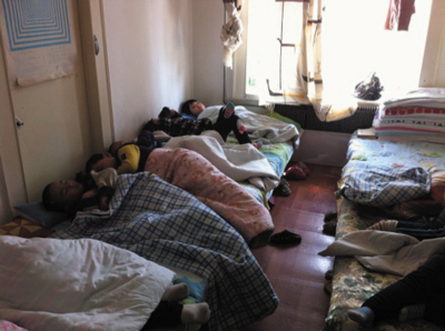 地板上摆两张大通铺十几个孩子正酣睡着(图)