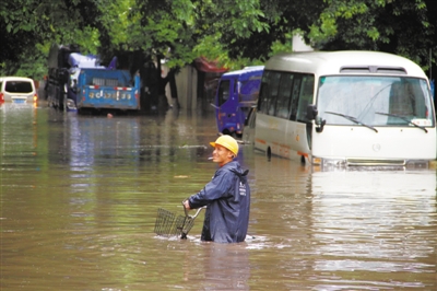 昨日，桂林市区，一名行人推车通过被水淹没的街道。4月29日至30日，广西、湖南、江西三省区遭遇强降水。 新华社发 任佳祥 摄