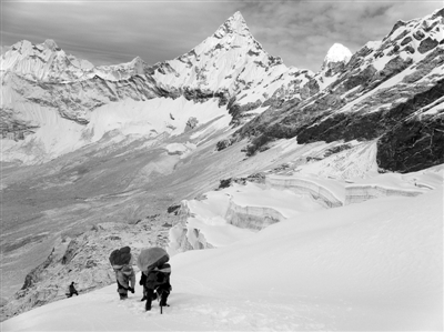 2009年，当地的夏尔巴人背负重物登山。