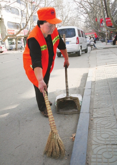 图5月1日,62岁的宝丰县清洁工杨新爱在自己的岗位上工作. 王双正摄