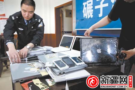 分局碾子沟派出所会议室,民警许边防在清点查获的高仿品牌手机和电脑