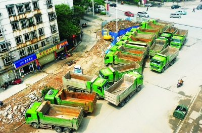 武昌才林东路，18辆渣土车聚集在路口停放。记者李子云摄