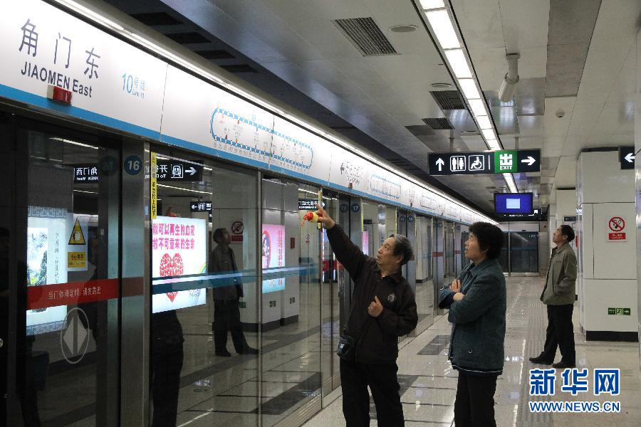 5月5日,乘客在刚刚开通的北京地铁10号线角门东站查看列车运行图.