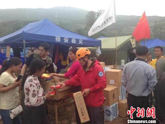 图为杭州市户外救援队队员在芦山灾区为当地民众发放救灾物资。