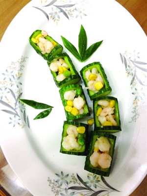 这道菜利用新鲜黄瓜做装饰,雕挖出数节空心的翠竹当成小器皿,内里
