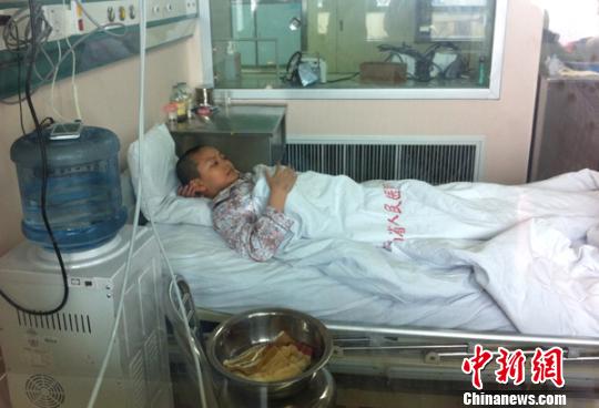 5月9日，化疗后的白血病男孩张吉祥躺在医院层流病房里静养 门杰丹 摄