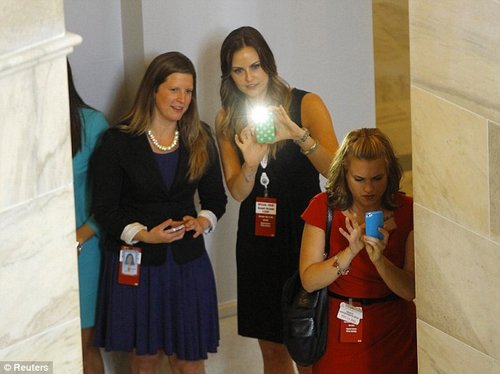 美国国会山的女员工躲在柱子后面为正在参观的哈里王子拍照。