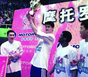 当年夺冠后，姚明作为球员代表高高举起奖杯合影。