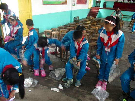 湖南省平江县长寿学区巨能学校的孩子们在试鞋