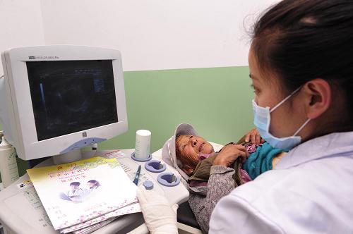 5月15日,拉萨城关区蔡公堂乡卫生院的医务人员在为藏族老阿妈做b超