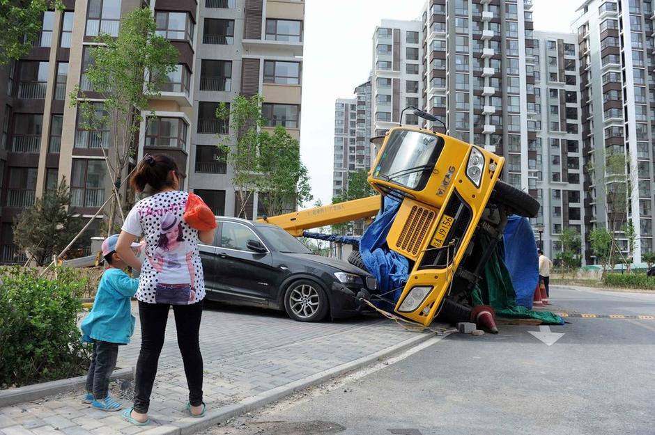 侧翻的吊车立在小区的路边,存在安全隐患.