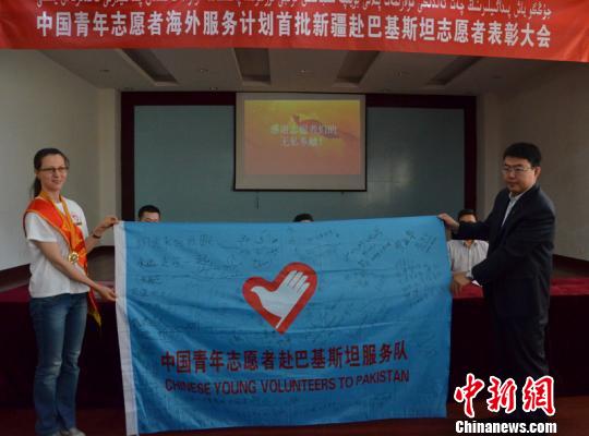 达吾来提向新疆志愿者协会交还援巴志愿服务队队旗. 孙亭文 摄