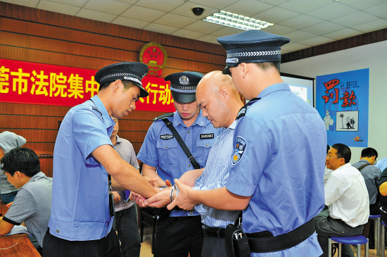 执法现场,一名"老赖"被铐上手铐