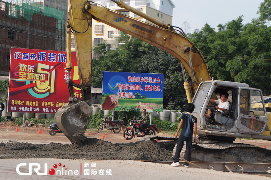 图为钦州浦北县张黄镇镇对过境公路进行硬底化建设.