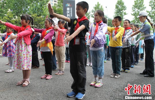 30日，重庆交巡警在重庆科技馆举办“大手拉小手、平安伴成长”庆六一主题活动。图为交巡警为小朋友讲解交通标志。周毅　摄